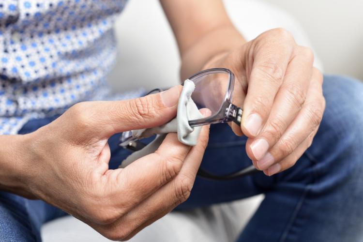 Personne qui nettoie ses lunettes