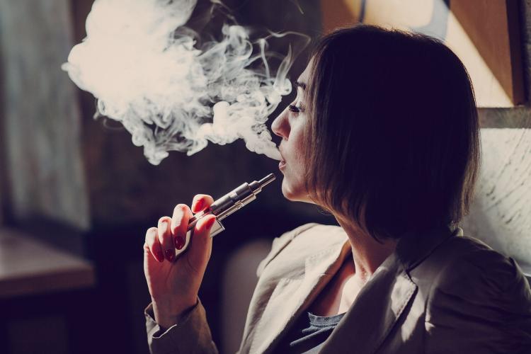 Femme qui fume avec une cigarette électronique