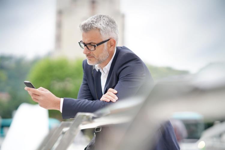 Homme qui regarde son téléphone en portant des lunettes